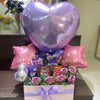 Gift basket with flowers, balloons, and candy on a table