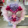 Bouquet of balloons shaped like a baby with a 'Welcome Baby' heart balloon, surrounded by pink and white ribbons.