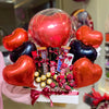 Bouquet of heart-shaped balloons and candy with a person holding it in a store setting.