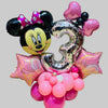 Decorative balloon arrangement with a cartoon character and number 8 on a tiled floor.
