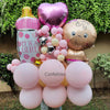 Balloon arrangement with 'It's a Girl' sign and baby-themed balloons outdoors.